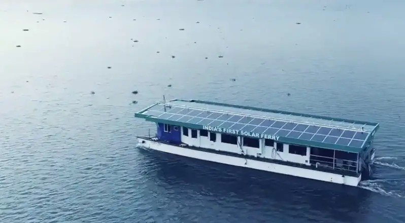 A fery boat with solar panels on top crossing a river