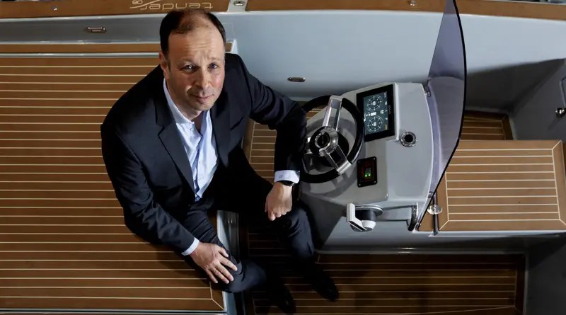 Torqeedo founder Christopher Ballin in the cockpit of a boat with controls for electric motors