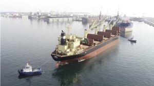 all electric tugboat 'Gisas Power' pulling huge ship in the harbour