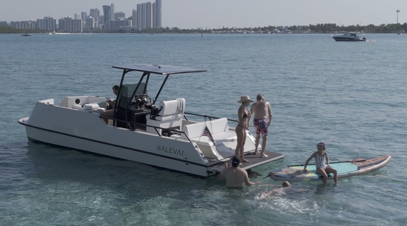 electric trimaran with people swimming, paddleboarding