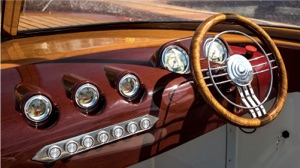 hydrofoiling electric boat has dashboard with wood steering wheel and gauges similar to a 1950s car interior