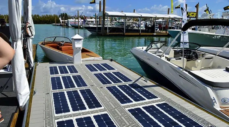 A dock with solar panels on it and a boat beside it