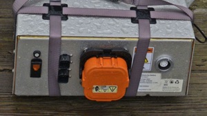 a demo electric boat battery pack held together with bungee cords and cables