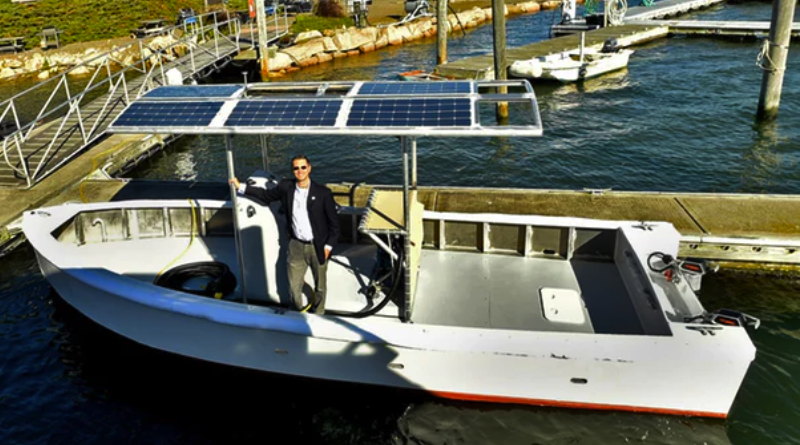 A man stands in s 20' boot with a solar panel on top